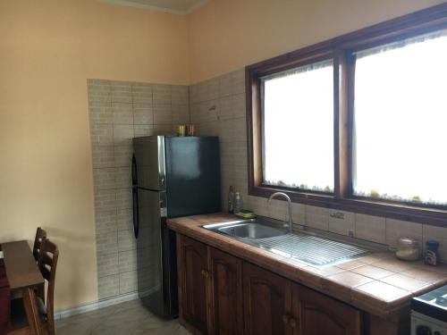 a kitchen with a sink and a refrigerator at Lazy Hill Bungalows in Bel Ombre