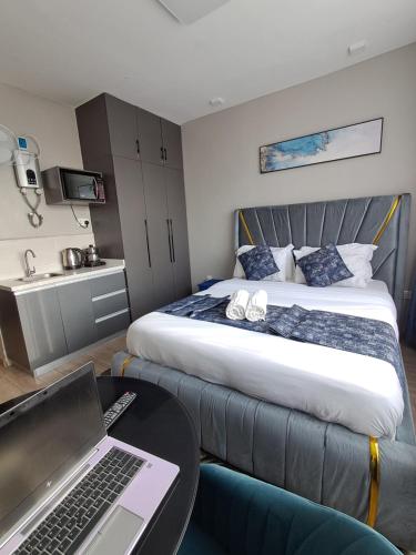 a hotel room with a bed and a laptop on a table at Favorite Staycation by Janice - Modern Comfort Near Airport in Nairobi