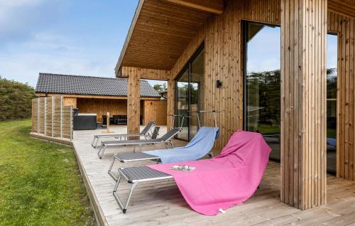 a deck with chairs and tables and a house at Amazing Home In Sæby With Sauna in Sæby