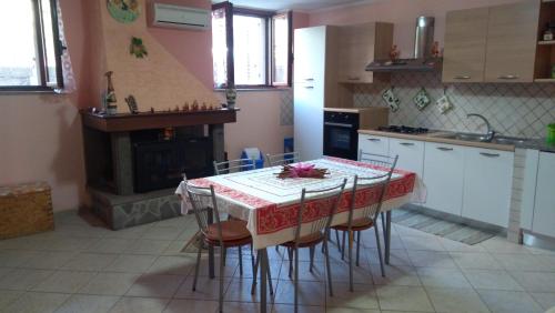 a kitchen with a table with chairs and a fireplace at Casa Anna in Bosa