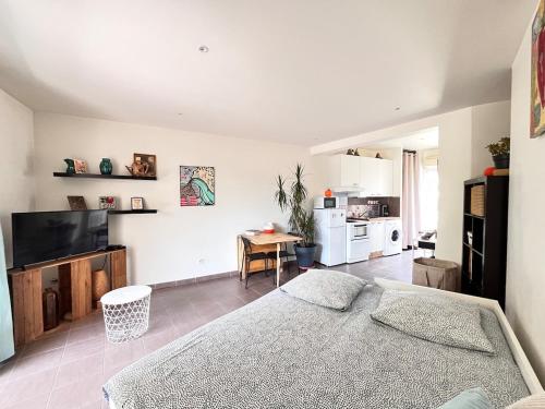 une chambre avec un lit et une table et une cuisine dans l'établissement MAISON CABROL, à Carqueiranne