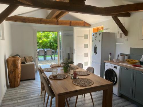 une cuisine avec une table en bois et une salle à manger dans l'établissement Location airial Landais, à Mimizan