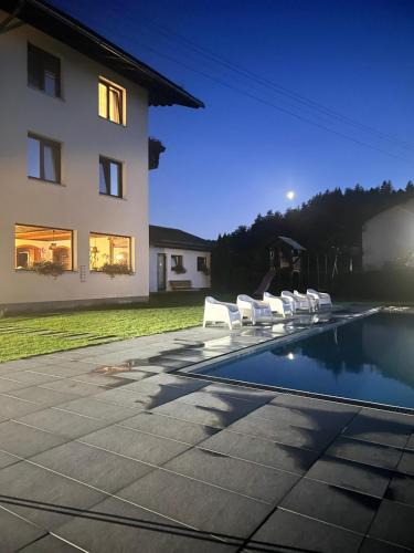 a group of white chairs sitting next to a house at Keutschacherhof in Keutschach am See