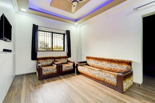 a room with two leather couches and a tv at Hotel O Sai Residenci in Lonavala