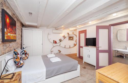 ein Schlafzimmer mit einem Bett, einem Fernseher und einem Tisch in der Unterkunft Apartment Potkova in Dubrovnik