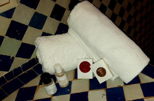 a roll of toilet paper on a bathroom floor with cosmetics at Palais AL Firdaous in Fès