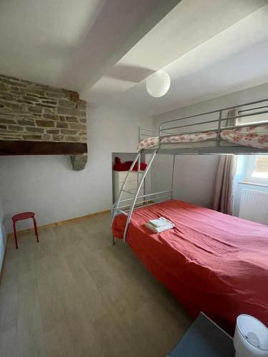 a bedroom with two bunk beds and a brick wall at Gîte à la campagne in Le Mesnil-Villeman