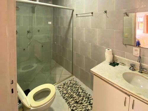 a bathroom with a shower and a toilet and a sink at Pousada Encantos da Serra Macacos in Macacos