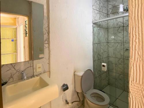 a bathroom with a sink and a toilet and a shower at Pousada Encantos da Serra Macacos in Macacos