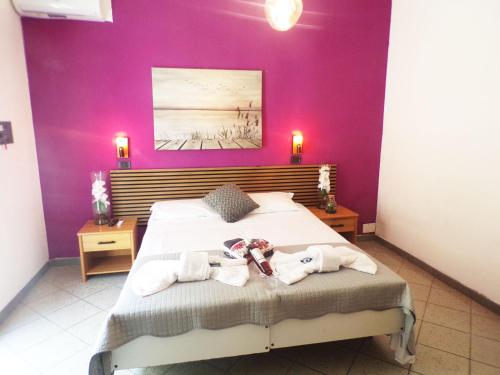 a bedroom with a large bed with purple walls at Hotel Litton Rimini nuova gestione in Rimini