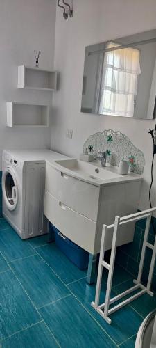 a bathroom with a sink and a washing machine at Casa Vacanze Miranda in Torre Dei Corsari