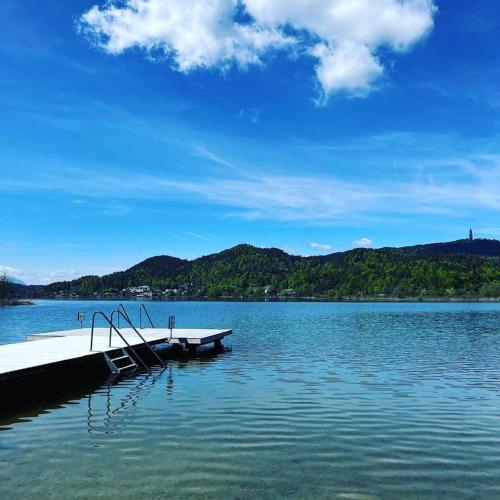a dock on a lake with mountains in the background at Keutschacherhof in Keutschach am See