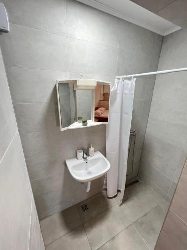 a white bathroom with a sink and a shower at Villa H&M in Baška Voda