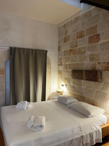 a bedroom with a large bed with towels on it at Dimora Noblac in Monopoli