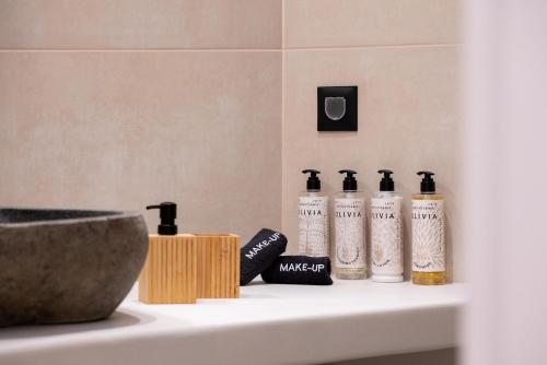 a bathroom sink with four bottles on it at AetherOia Suites in Oia