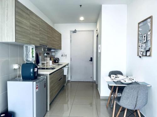 a kitchen with a refrigerator and a table with chairs at Neko Homes at i-City - WiFi TV Box 1 Carpark in Shah Alam