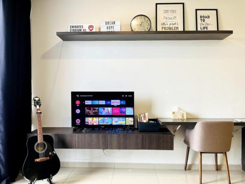 a room with a guitar and a desk with a television at Novel Homes at i-City - WiFi TV Box 1 Carpark in Shah Alam