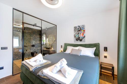 a bedroom with a large bed with towels on it at POOL me up! in Šibenik