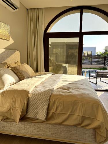 a bed in a bedroom with a large window at WeTake Hawana in Salalah
