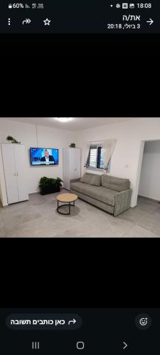 a living room with a couch and a tv at הבית של רביבו in Sderot