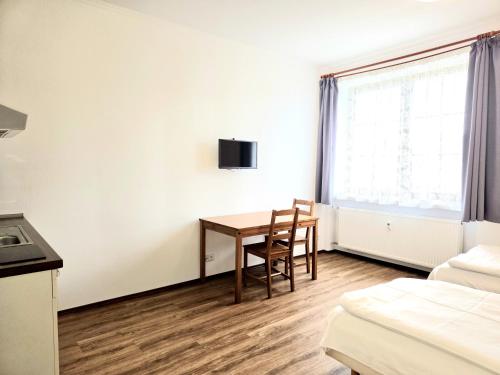 a room with a desk and a table and a bed at Penzion Vintrovna in Popůvky