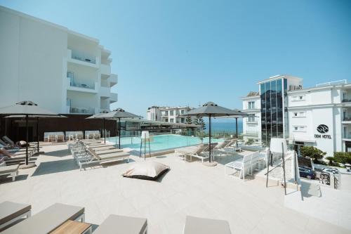 a patio with a pool and chairs and umbrellas at Hotel Agimi in Sarandë