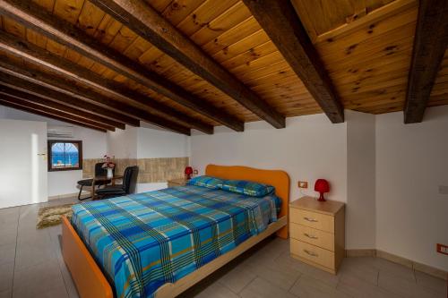 sypialnia z łóżkiem i drewnianym sufitem w obiekcie Casa Vacanze Cappuccini w mieście Castellammare del Golfo