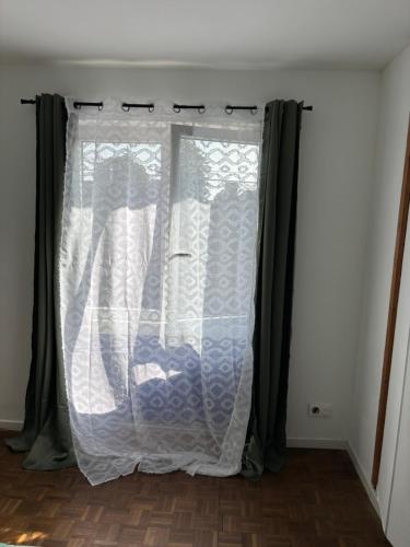 a window with a white curtain in a room at G&J fourmidables in Récourt