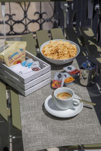 a table with a cup of coffee and a plate of food at Maison Le Blanc Luxury B&B in Giovinazzo