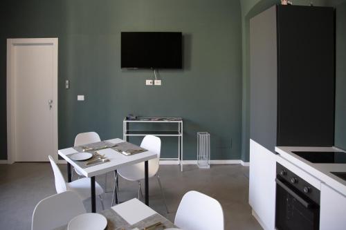 a kitchen with a table and chairs and a tv at Maison Le Blanc Luxury B&B in Giovinazzo