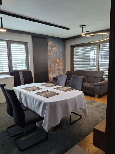 a dining room with a table with chairs and a couch at 3 Zimmer Wohnung in Maria Lanzendorf