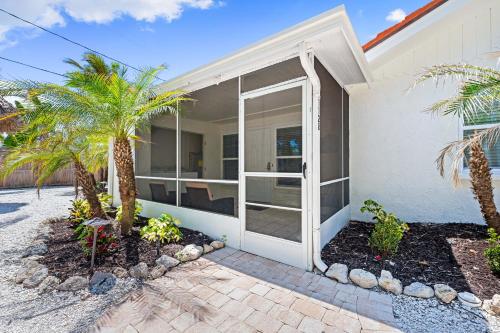 a white house with palm trees in front of it at Bianco Sands By Beachside Management in Siesta Key