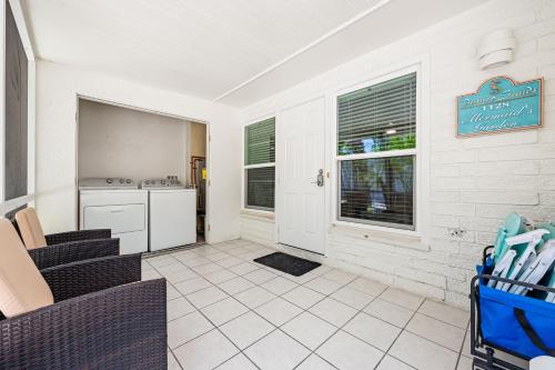 a living room with a table and chairs and a kitchen at Bianco Sands By Beachside Management in Siesta Key