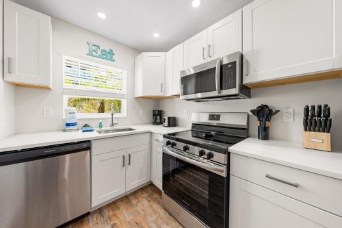 a kitchen with white cabinets and stainless steel appliances at Bianco Sands By Beachside Management in Siesta Key