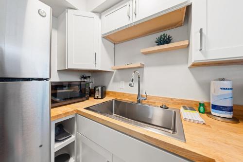 a kitchen with a stainless steel sink and white cabinets at Bianco Sands By Beachside Management in Siesta Key