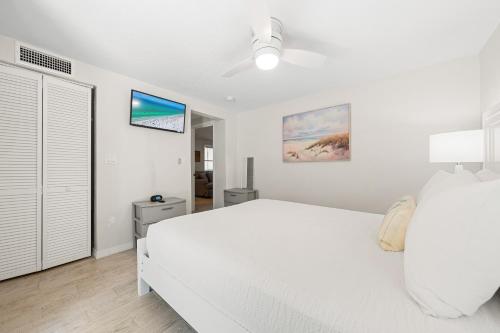 a white bedroom with a large white bed in it at Bianco Sands By Beachside Management in Siesta Key