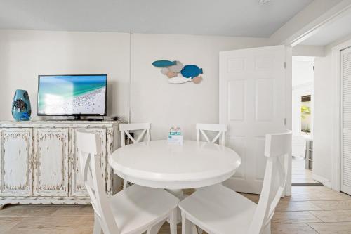 a white dining room with a white table and chairs at Bianco Sands By Beachside Management in Siesta Key