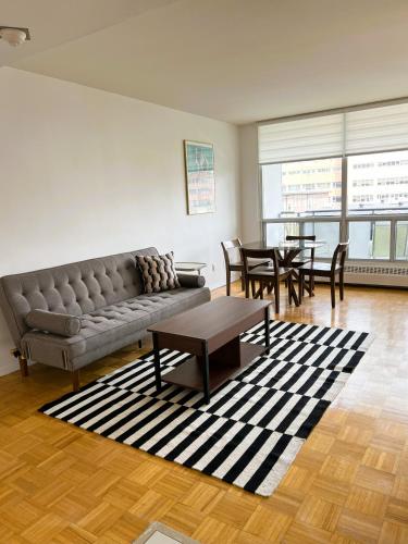 a living room with a couch and tables and chairs at The Charming Downtown Stop in Toronto