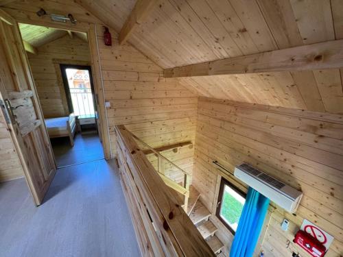 een raam met uitzicht op een houten huisje bij Domek nad jeziorem Jan, Giże in Giże