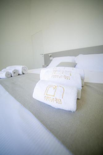 a row of white towels sitting on a bed at Maison Le Blanc Luxury B&B in Giovinazzo