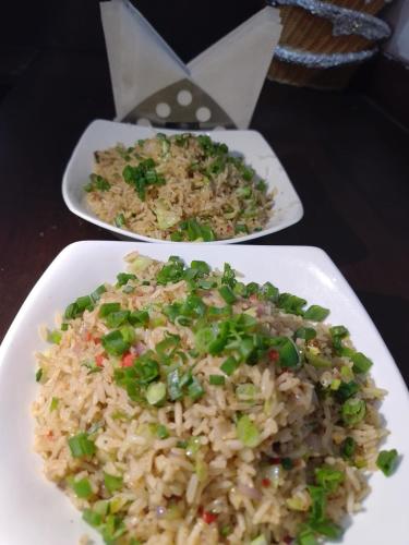 two plates of rice and vegetables on a table at Hotel Holiday Hill Mcleodganj-Near to Dalai Lama Temple & Mall Road in Dharmsala