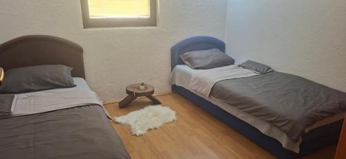 a bedroom with two beds and a white rug at Camp Krivace in Pljevlja