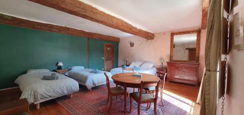 a room with two beds and a table in it at La Grande Vesvre in Gigny