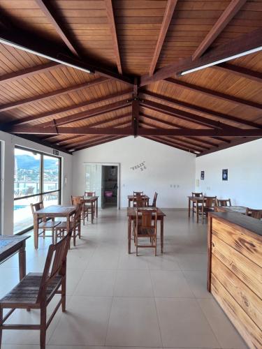 a restaurant with wooden ceilings and tables and chairs at Pousada Capitólio in Capitólio