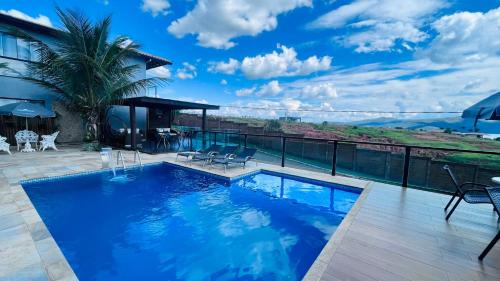 a pool on the roof of a house with a view at Pousada Capitólio in Capitólio