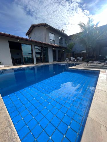 a swimming pool in front of a house at Pousada Capitólio in Capitólio