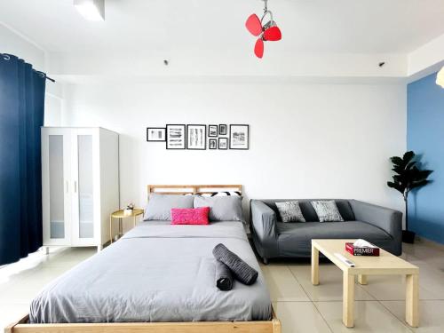 a bedroom with a bed and a couch at Oasis Homes at i-City - WiFi TV Box and 1 Carpark in Shah Alam