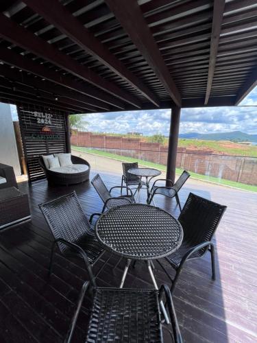 a patio with a table and chairs and a couch at Pousada Capitólio in Capitólio