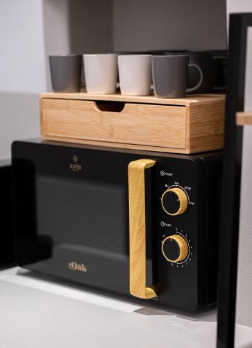 a black microwave with cups on top of it at AetherOia Suites in Oia