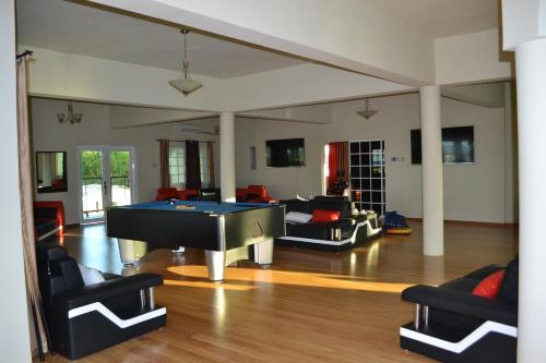 a living room with a pool table in it at Negril Sky Blue Resorts LTD in Negril